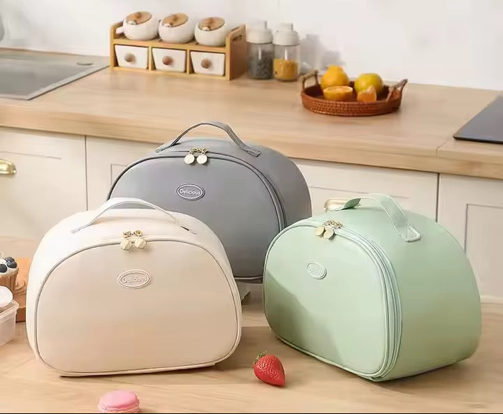 Three insulated food bags in gray, beige, and green on a kitchen counter.